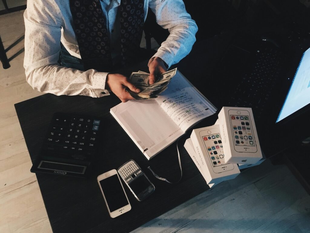 pexels-photo-210990-210990 Businessman organizing finances with tech devices and cash on desk.