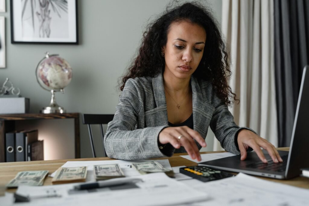 pexels-photo-6693656-6693656 Professional woman analyzing financial documents and counting cash at office desk.