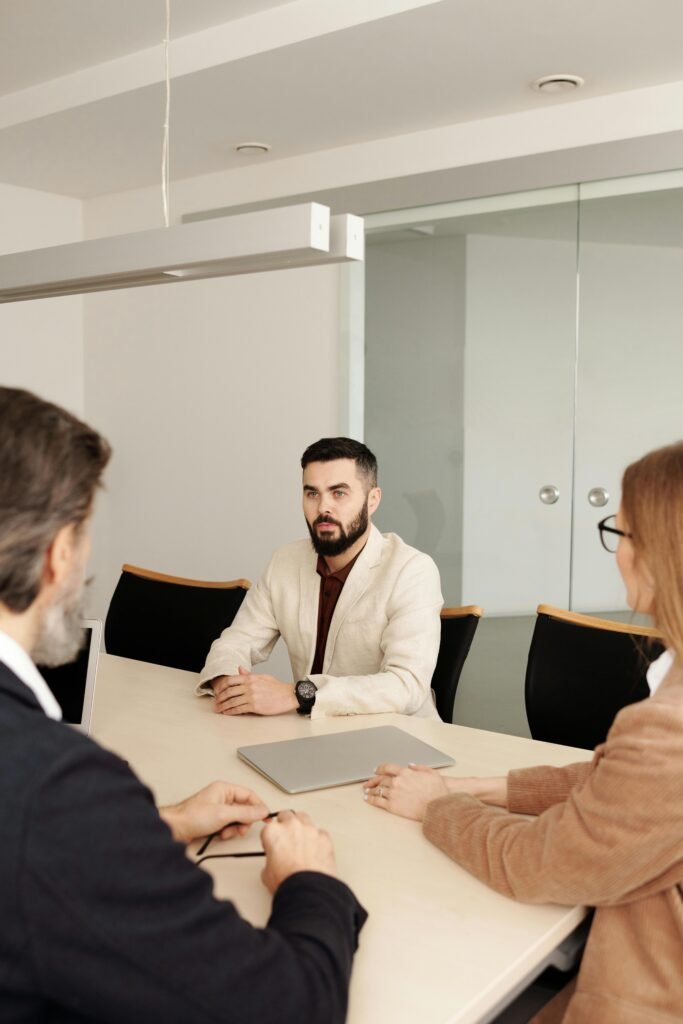 pexels-photo-4342128-4342128 Three professionals engaged in a business meeting around a table in a modern office setting.